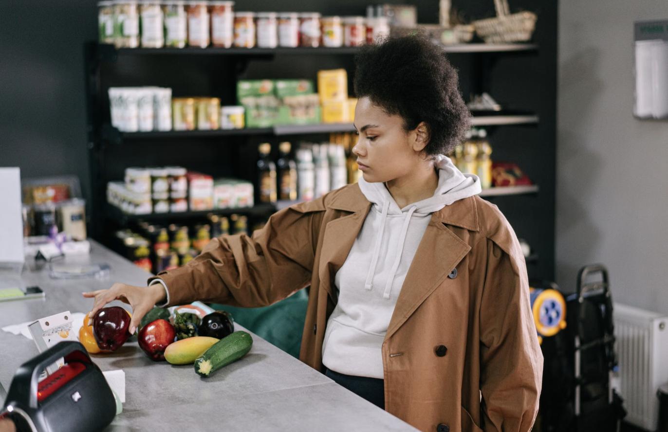 Femme qui fait son épicerie en surveillant son budget parce que ses dettes limitent ses dépenses essentielles