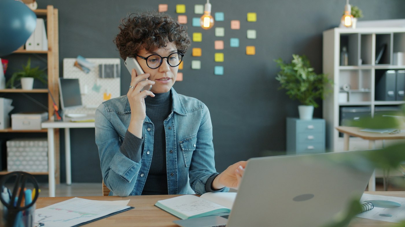 Woman taking notes on the phone during a free consultation with a Licensed Insolvency Trustee
